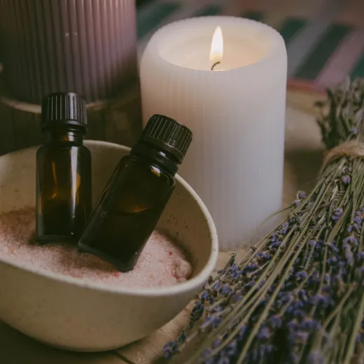 Bottles of aroma oils, a candle and sprigs of lavender