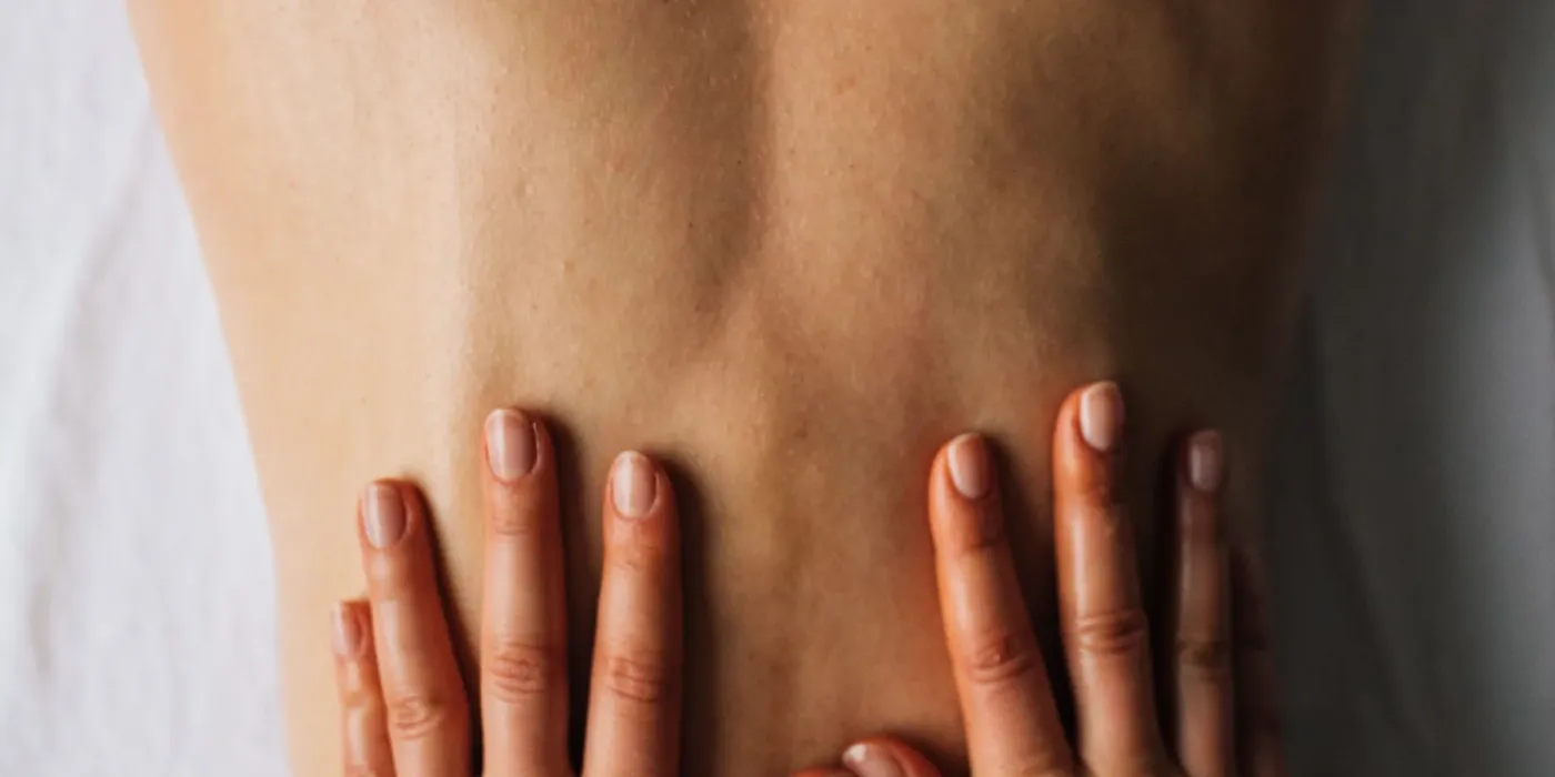 Close-up of a massage therapist’s hands working on trigger points in the back