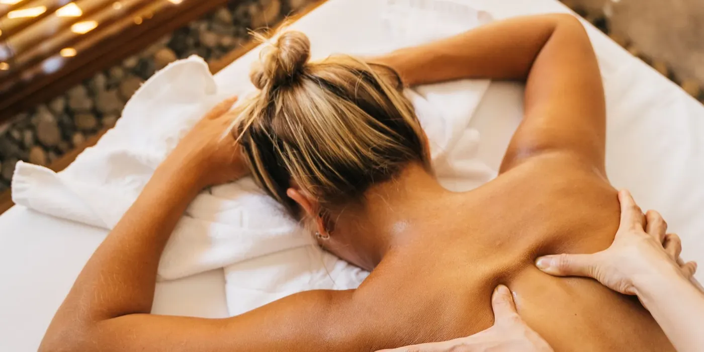 A massage therapist giving an oil back massage by candlelight — a custom massage at the Wau Wau studio