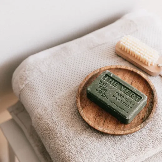Natural soap, a towel and a brush laid out for a massage