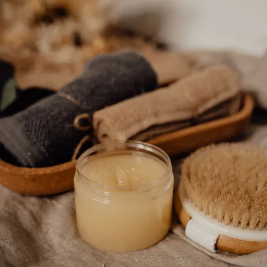 Folded towels, a tub of balm and a brush
